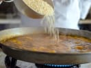 Cooking Class - Paella and Spanish Tapas Workshop in Washington, D.C.: pouring rice into paella