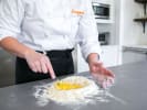 Cooking Class - Handmade Pasta and Alfredo at a Global Restaurant in Minneapolis: preparing fresh pasta dough with Cozymeal apron on