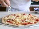 Team Building Cooking Class - Pizza-Making With Your Team in Toronto: putting cheese on pizza dough