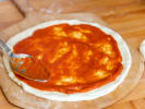 Cooking Class - Artisan Pizza 101 in Downtown Sacramento: putting tomato sauce on a pizza