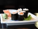 Cooking Class - Make Perfect Sushi Rolls in Minneapolis: salmon sushi maki rolls on a white plate with garnishes