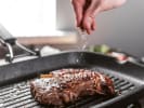 Cooking Class - Elevated Fall Steak Dinner - Date Night in Naperville: seasoning steak on a grill pan