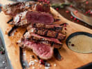 Cooking Class - Quintessential French Brasserie in Northern Suburbs: sliced medium-rare steak served on wooden cutting board with a mustard sauce