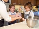Cooking Class - Baking Masterclass: Teen Summer Series in Northern Suburbs: female chef helping a boy and a girl to prepare batter