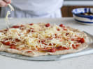 Cooking Class - A Grilled Pizza Soirée: topping a homemade pizza with cheese