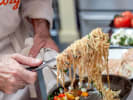 Cooking Class - Seasonal Italian Feast With Fresh Pasta in Austin: tossing spaghetti pasta in a pan with fresh tomatoes