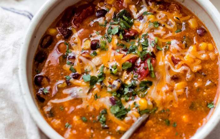 easy cheesy bean and rice enchilada soup is a warm and comforting vegetarian soup recipe