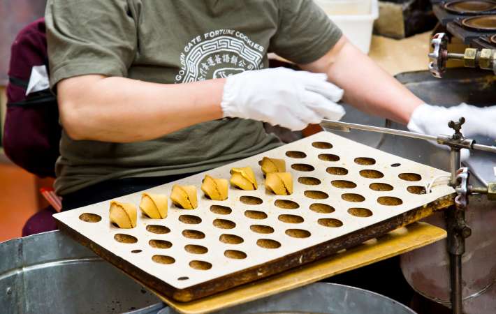 Person making fortune cookies at the fortune cookie factory in san francisco