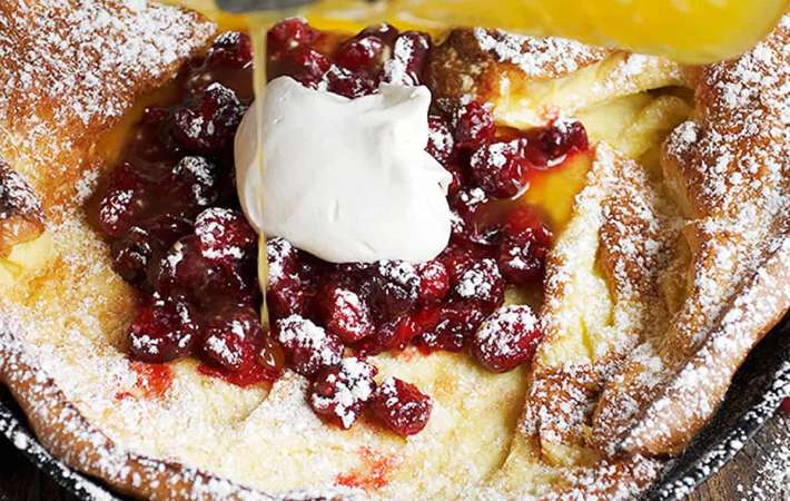 bright cranberries and oranges come together in this cranberry dutch baby with clementine oranges