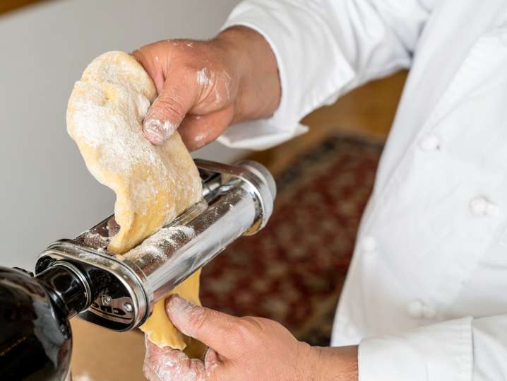 passing homemade pasta dough through a pasta roller Shot