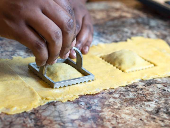 chef's hands stamping ravioli with a ravioli press Shot