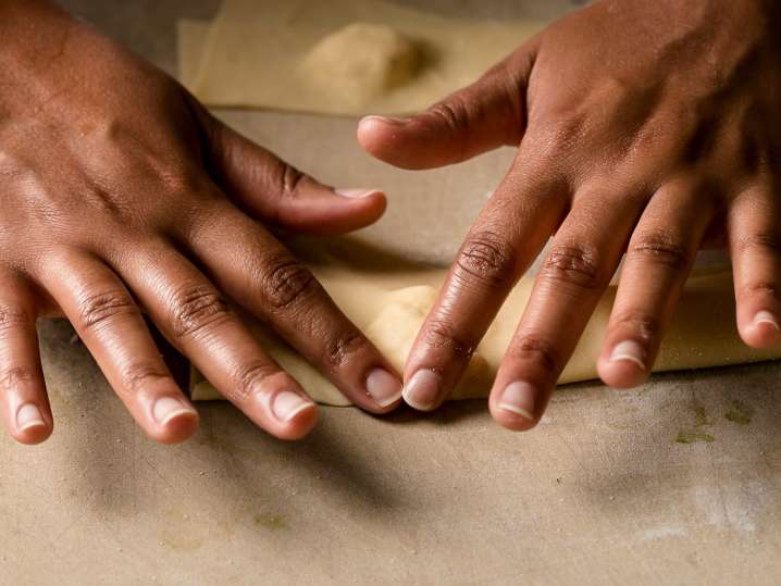 chef hands working with fresh sheet of pasta dough Shot