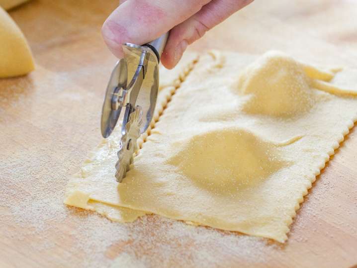 chef using cutting tool to cut ravioli Shot