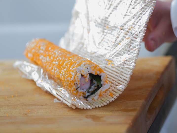 chef rolling sushi with a bamboo mat Shot