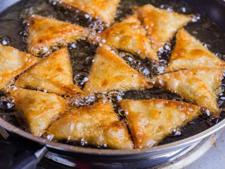 samosas frying in hot oil Shot