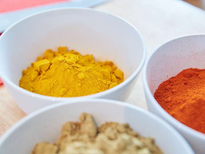 turmeric, cumin, and garam masala in white bowls Shot