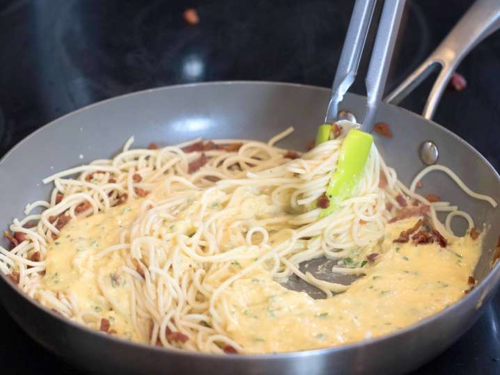 mixing spaghetti and carbonara sauce Shot