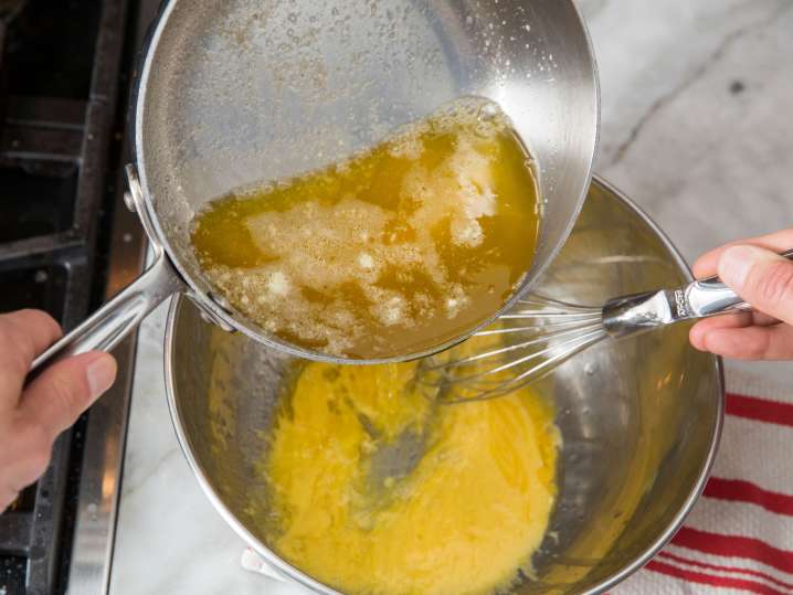 whisking butter into egg yolks to make hollandaise sauce Shot