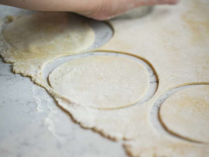 cutting circles of empanada dough Shot