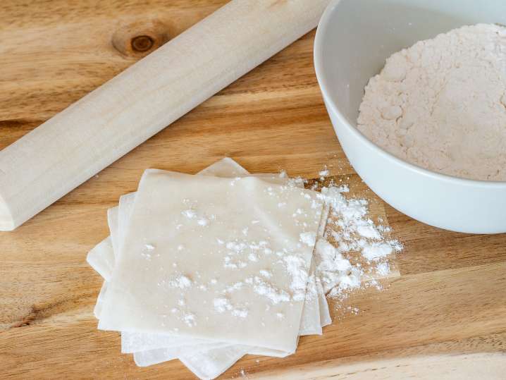 wonton wrappers and flour on a butcher block Shot