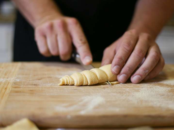 chef cutting fresh pasta dough into ribbons Shot