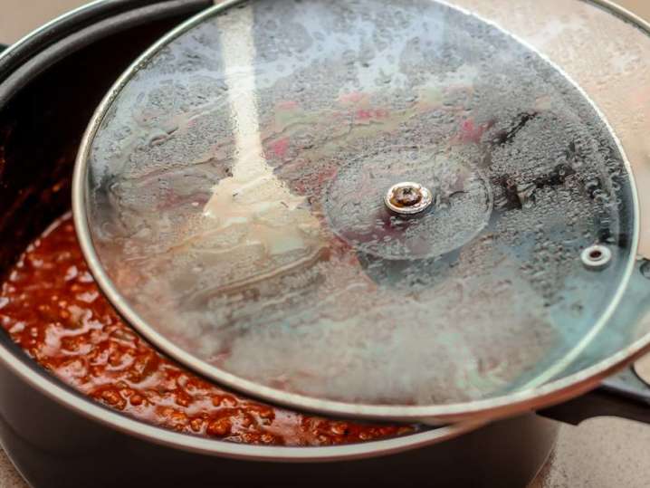 wooden spoon stirring homemade tomato sauce in a pot Shot