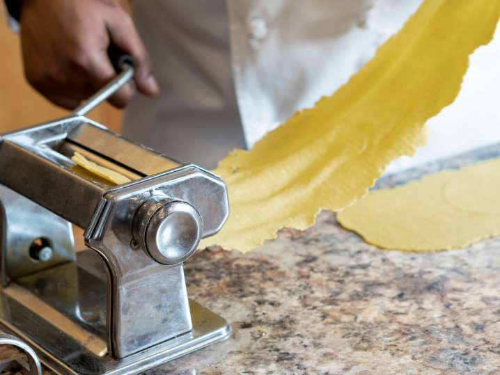 chef rolling sheet of fresh pasta dough Shot