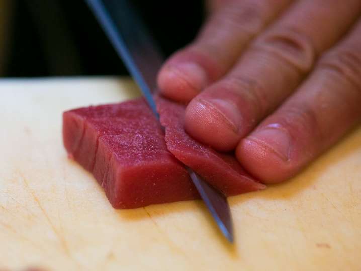 chef slicing fresh tuna to make sushi Shot