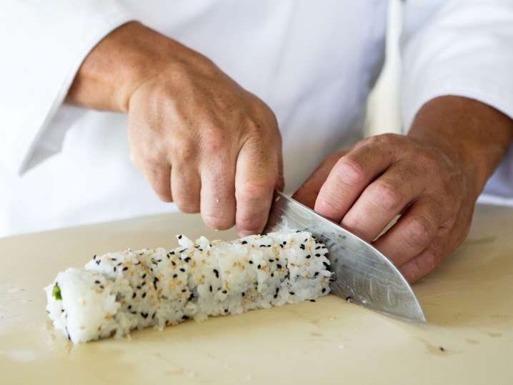 chef slicing a sushi roll Shot