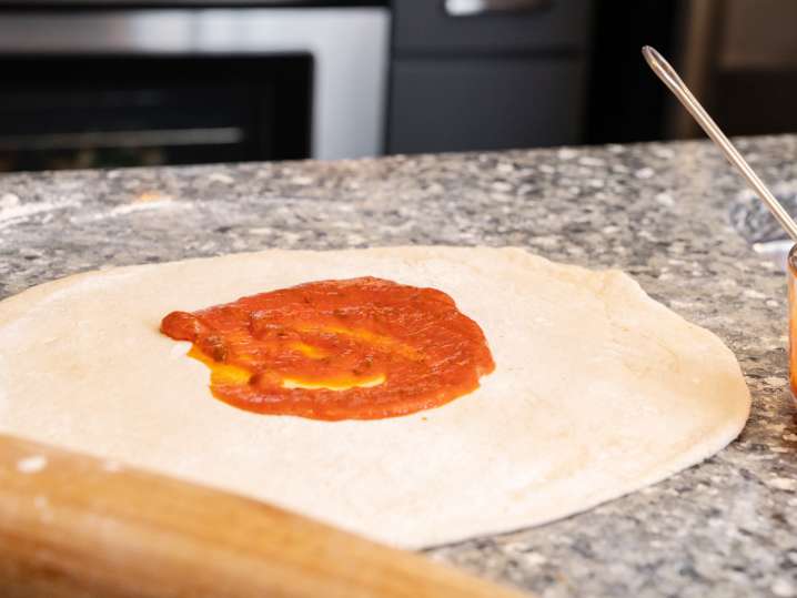 flatbread pizza dough with sauce on top Shot