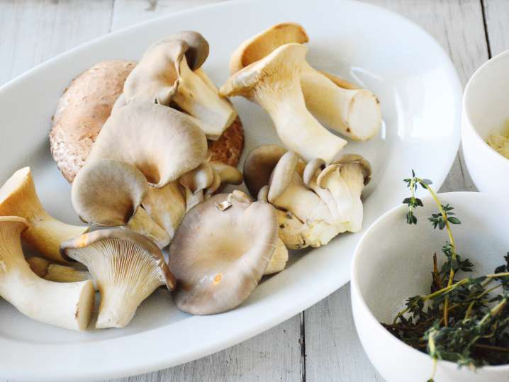 mushrooms and herbs in while bowls Shot