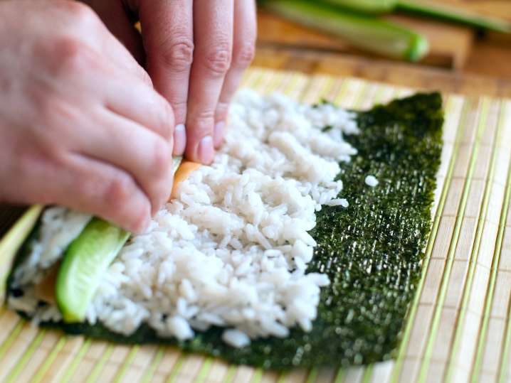 chef rolling sushi on a bamboo mat Shot