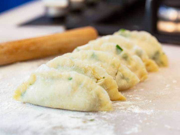 chef holding wonton wrapper with siu mai filling Shot