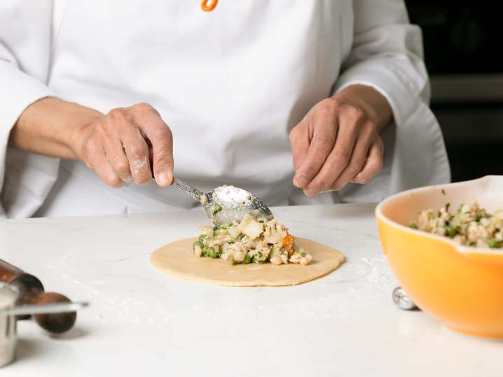 chef filling an empanadad Shot