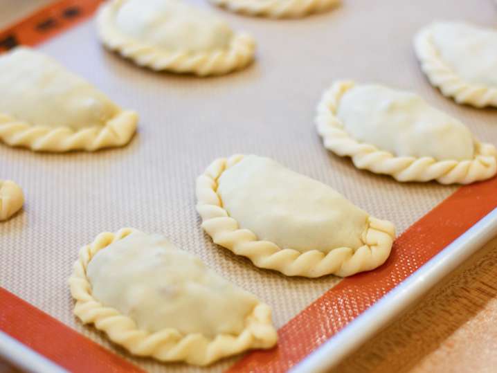 chefs hands folding an empanadas Shot