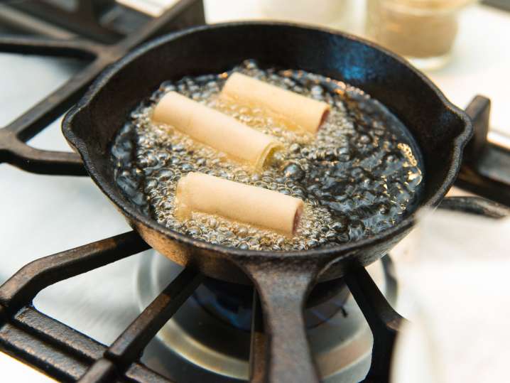 egg rolls frying in hot oil Shot