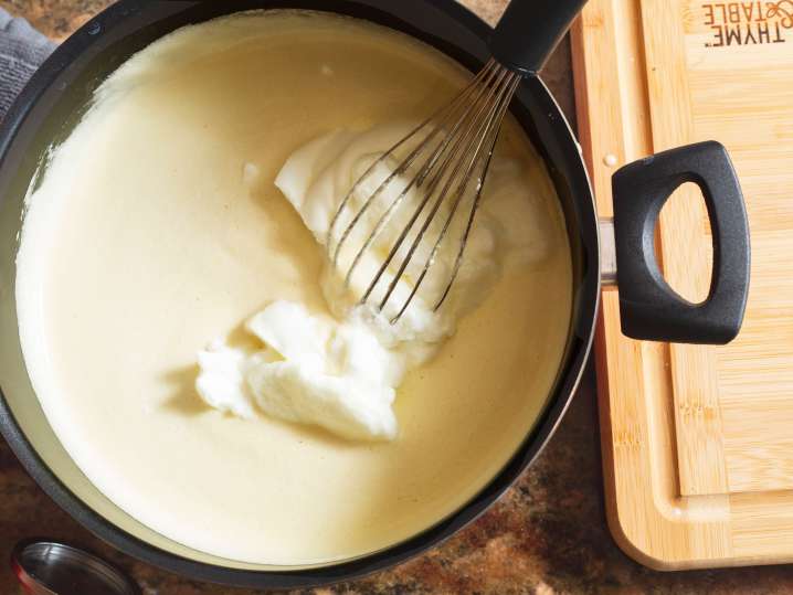 whisk stirring cheese sauce Shot