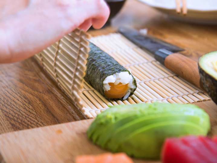 chef rolling sushi on a bamboo mat Shot