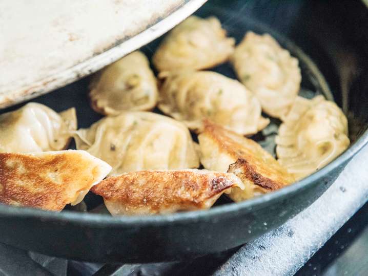 pot stickers frying in a cast iron pan Shot