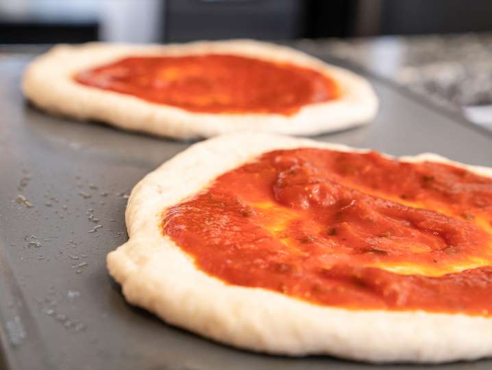 Pizzas With Sauce on Baking Tray Shot