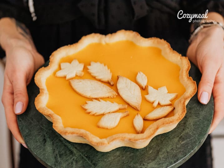 holding freshly baked BrÃ»lÃ©ed Pumpkin Chai Spice Pie