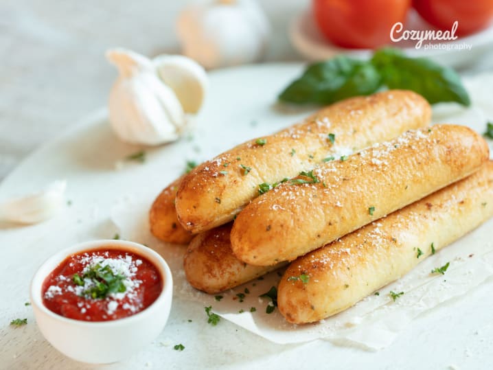 Garlic-seasoned breadsticks sprinkled with herbs and served with marinara.
