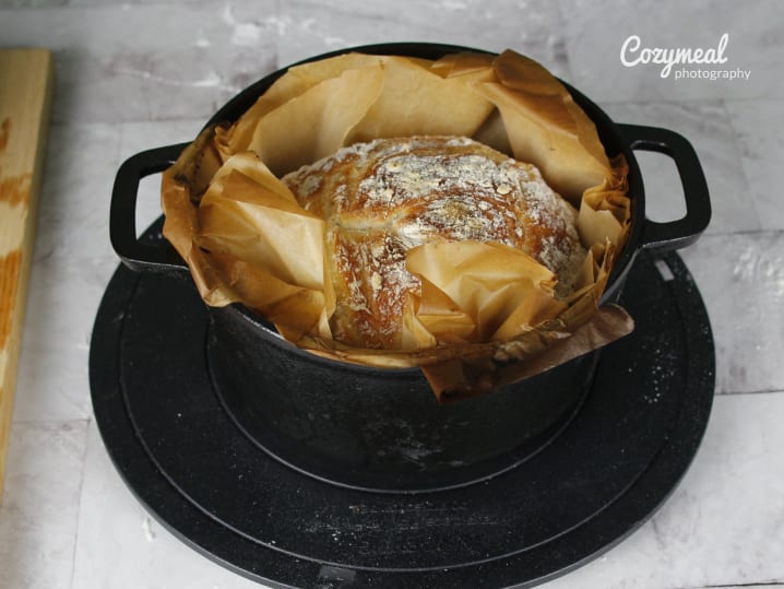 Rustic Dutch oven bread baked in parchment in a cast iron pot.