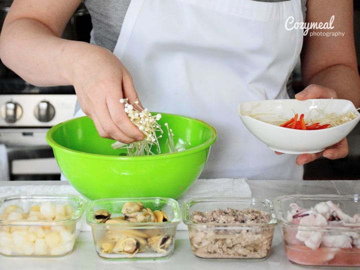 Prepping ingredients at a counter for multiple Thai dishes, including noodles and vegetables.
