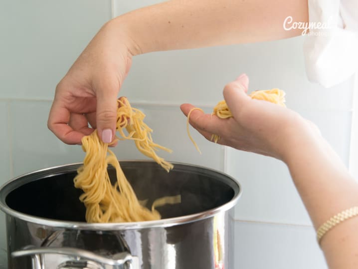 putting fresh spaghetti to a pot of boiling water