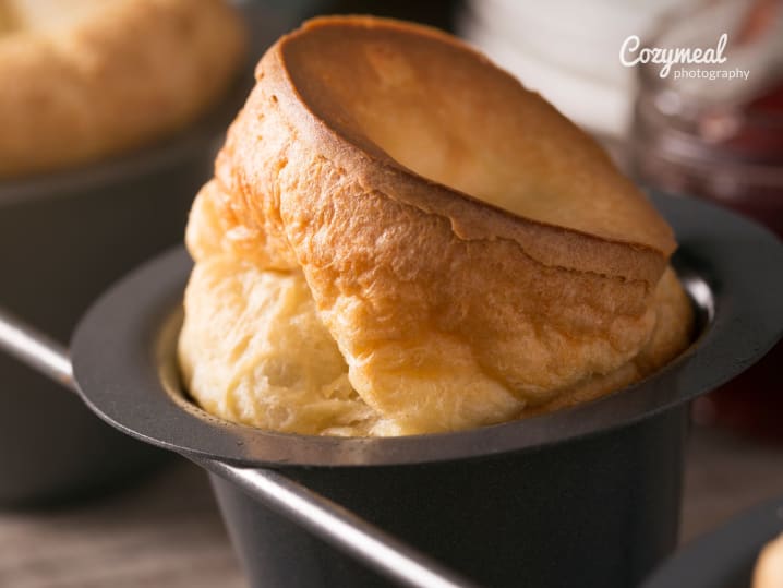 Tall, fluffy thyme and GruyÃ¨re popover in a black muffin tin.