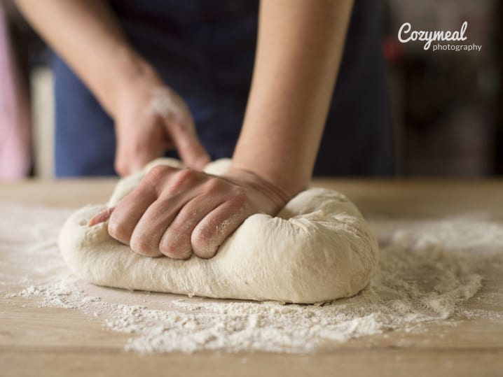 Kneading bread dough by hand on a floured surface.