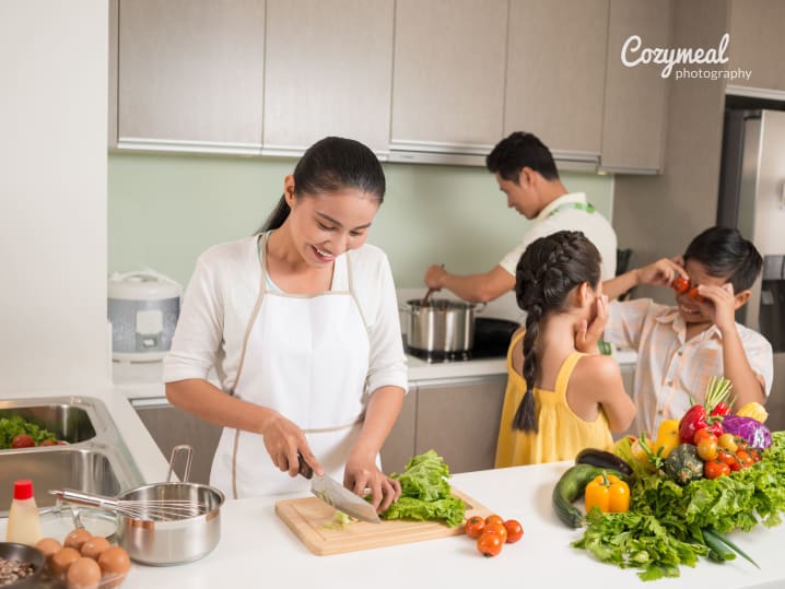 family cutting vegetables in the kitchen together
