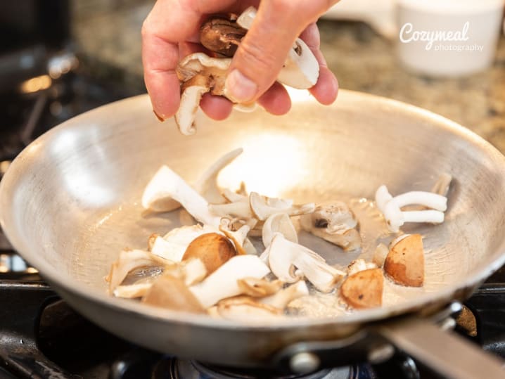 close up of adding mushrooms in a steel pan