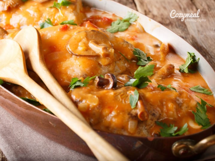 Chicken Chasseur (Chicken in Hunter Sauce) with two wooden spoons on the side